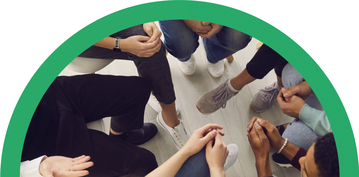 Manos y pies de personas en un grupo de terapia para adicciones